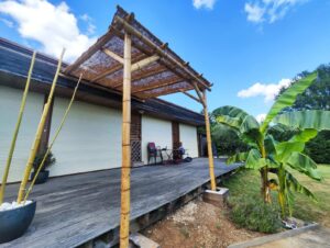 Pergola en bambou adossée à la maison, avec ombrage naturel. Une solution élégante pour créer un espace de détente.