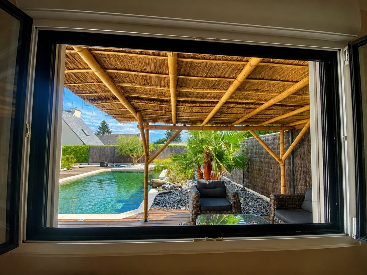 vue d'une pergola bambou, maison et piscine
