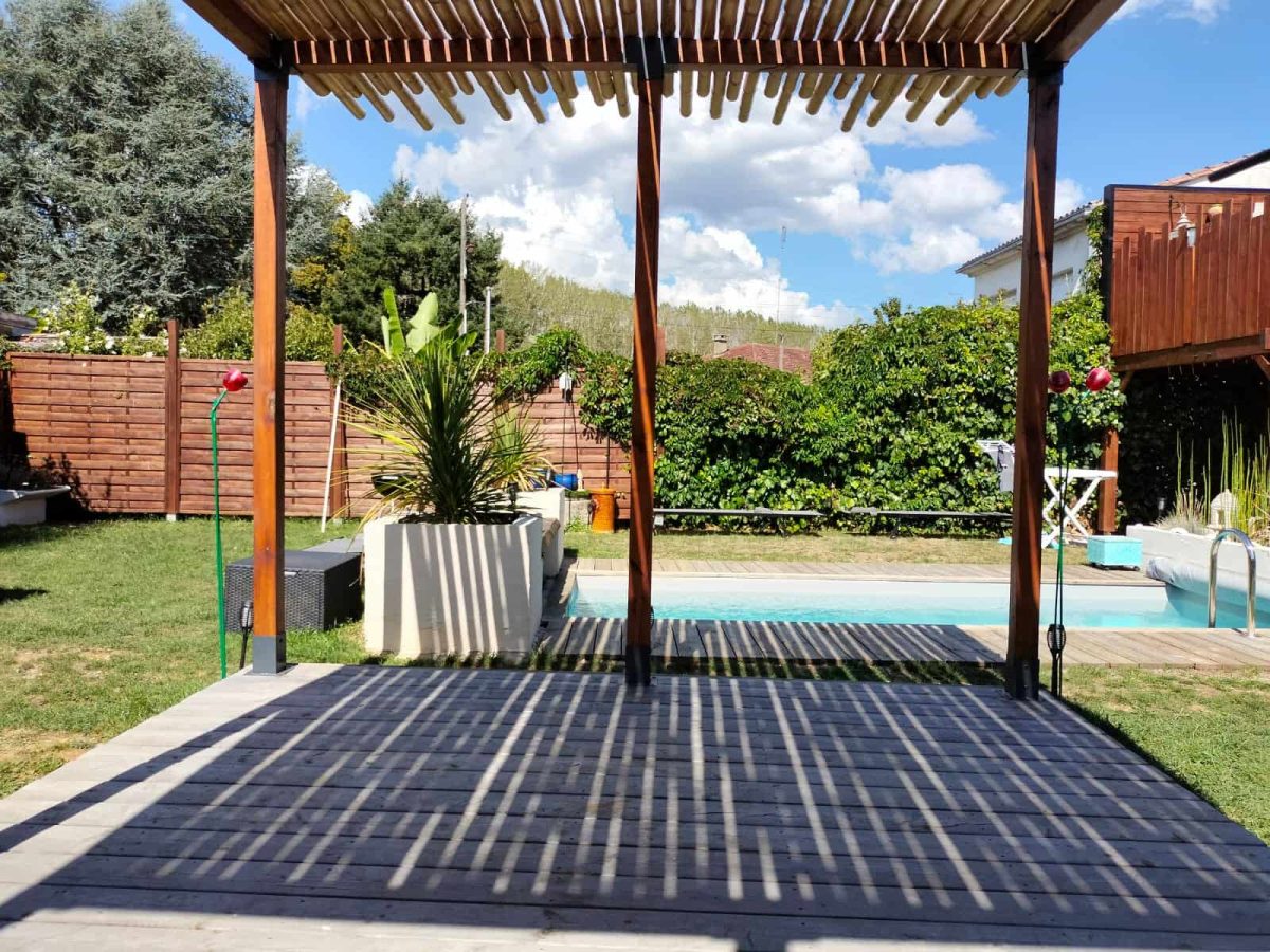 pergola en bambou au bord d’une piscine avec ombres projetées au sol
